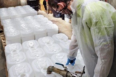 Haviland employee fills hand-sanitizer jugs